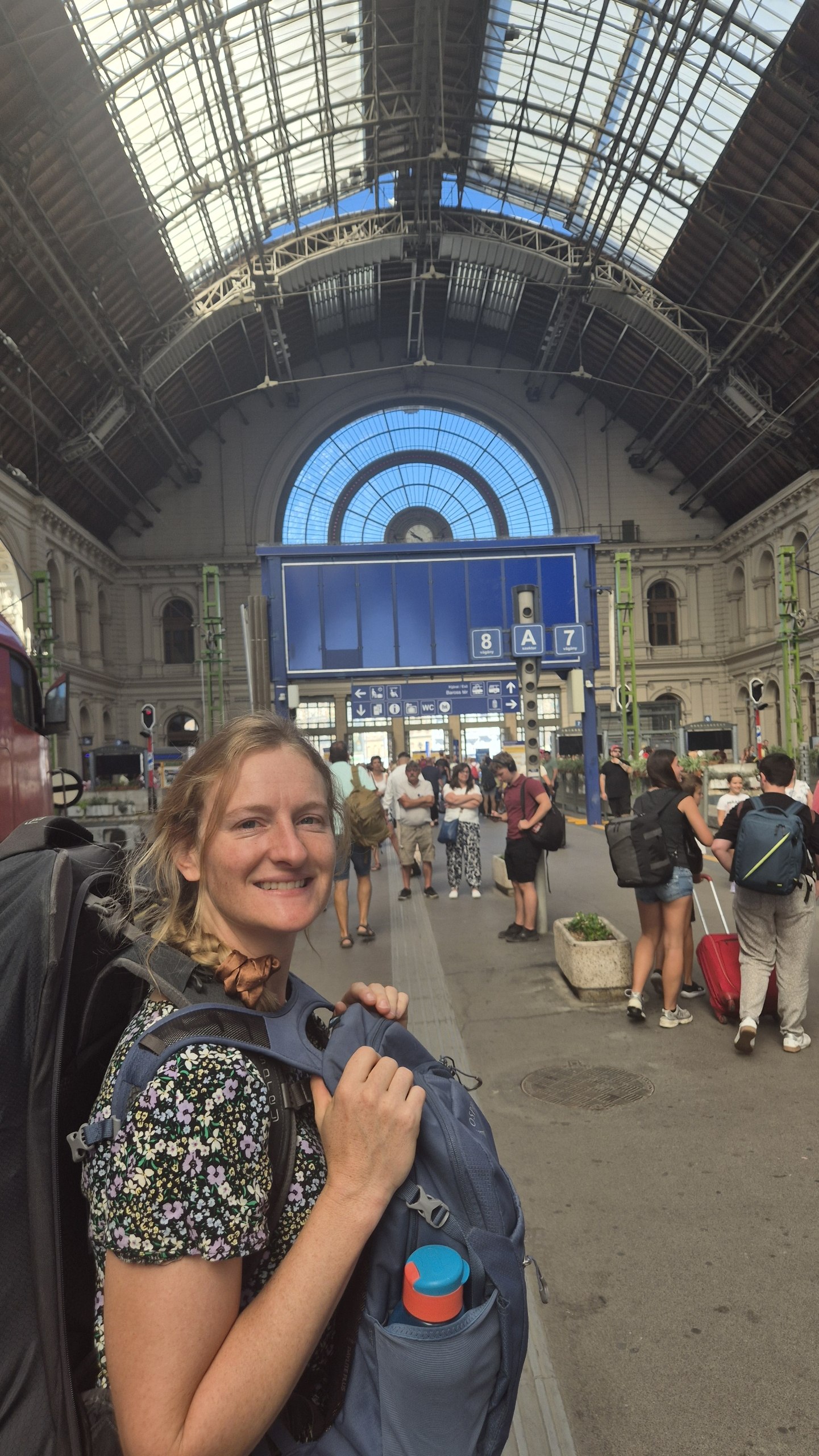 Caro carrying both backpacks inside Budapest Keleti railway station