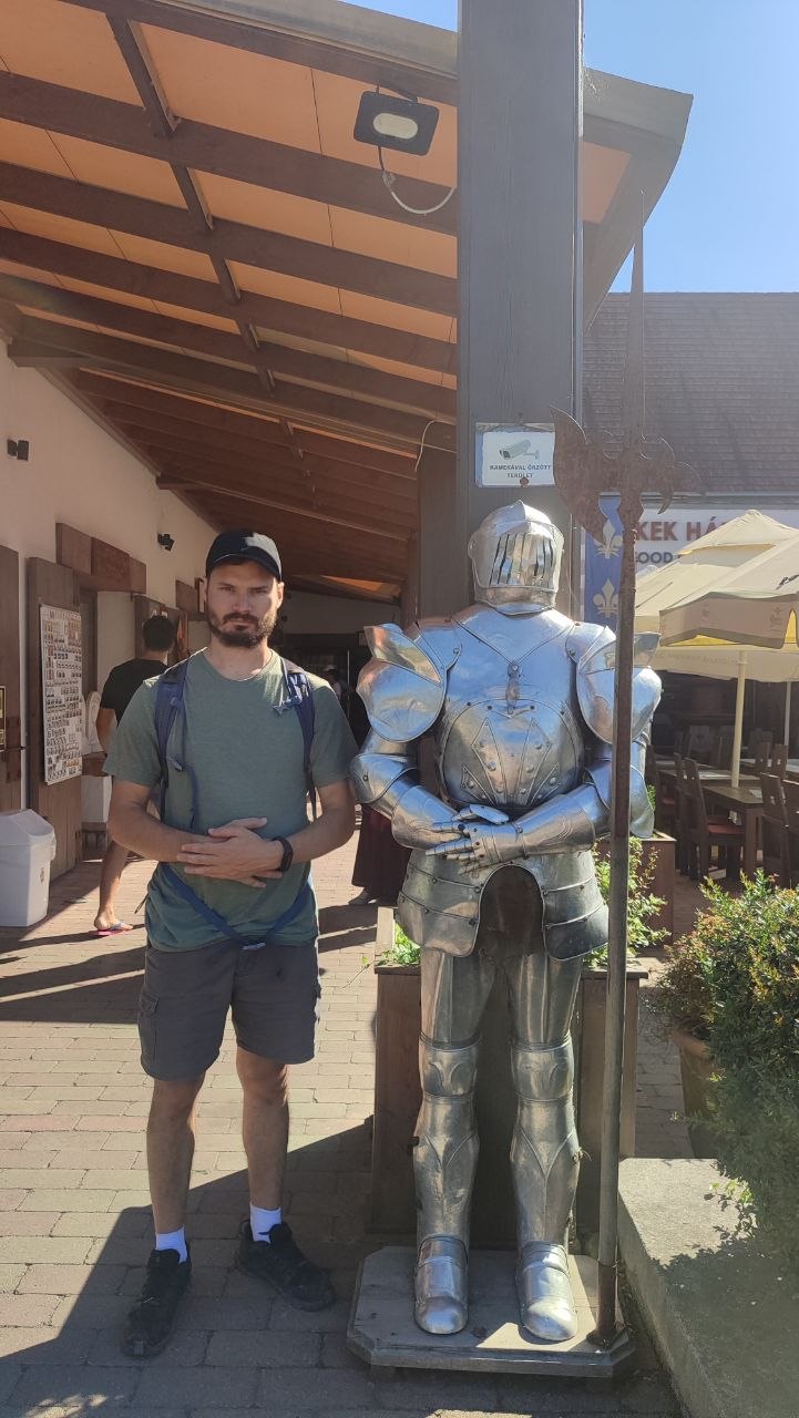 Hugo standing beside a suit of armour at Visegrád Citadel