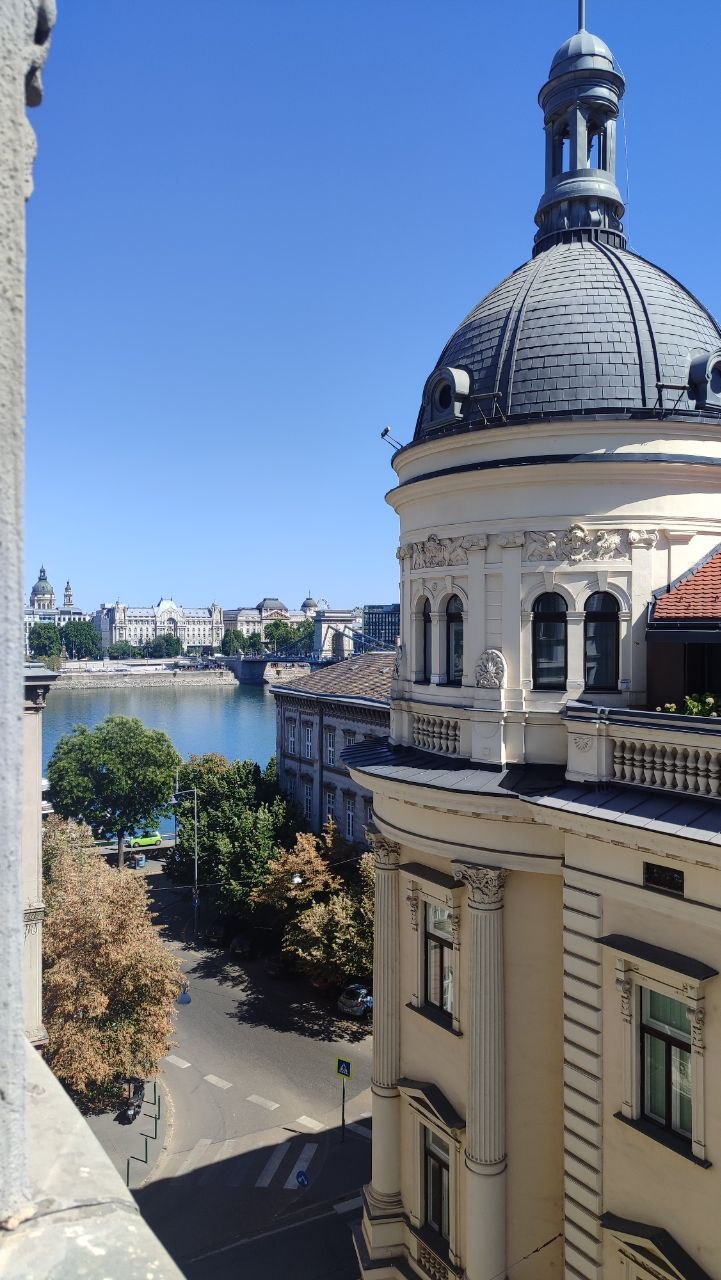View from our Budapest apartment past an ornate domed building towards the Danube and Chain Bridge