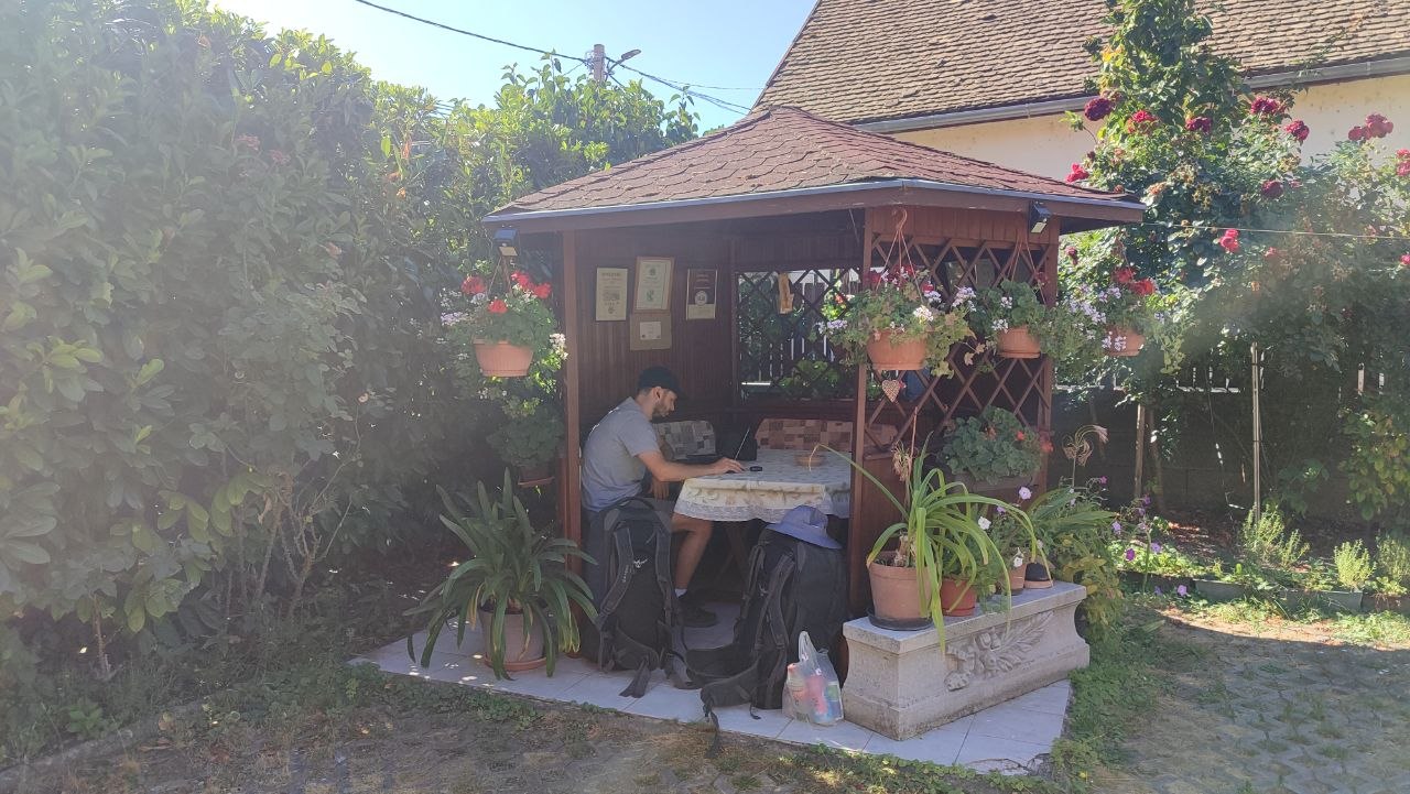 Hugo attending a work meeting from the flower-filled pergola at our Visegrád guesthouse