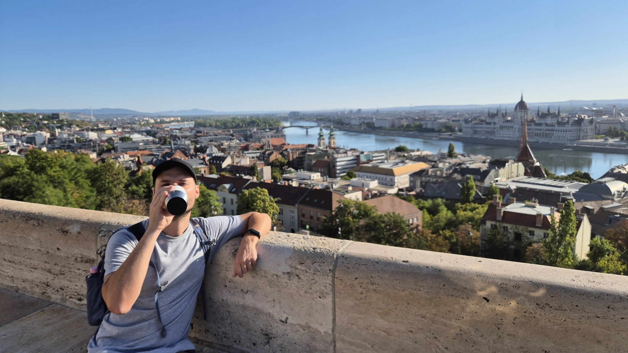 Hugo drinking coffee at Fisherman's Bastion overlooking the Danube and Parliament