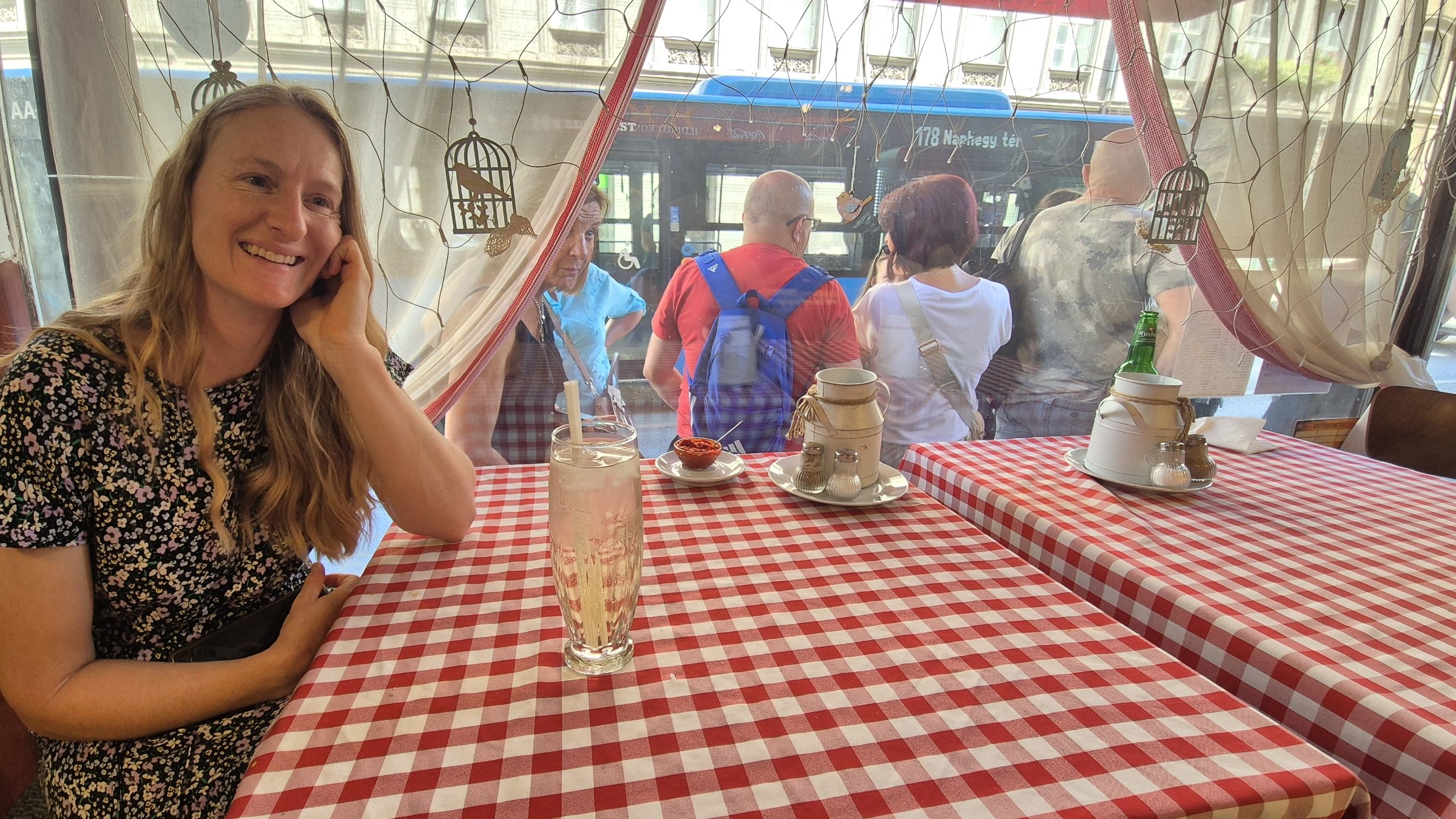 Caro sitting at the window table in the busy Budapest restaurant