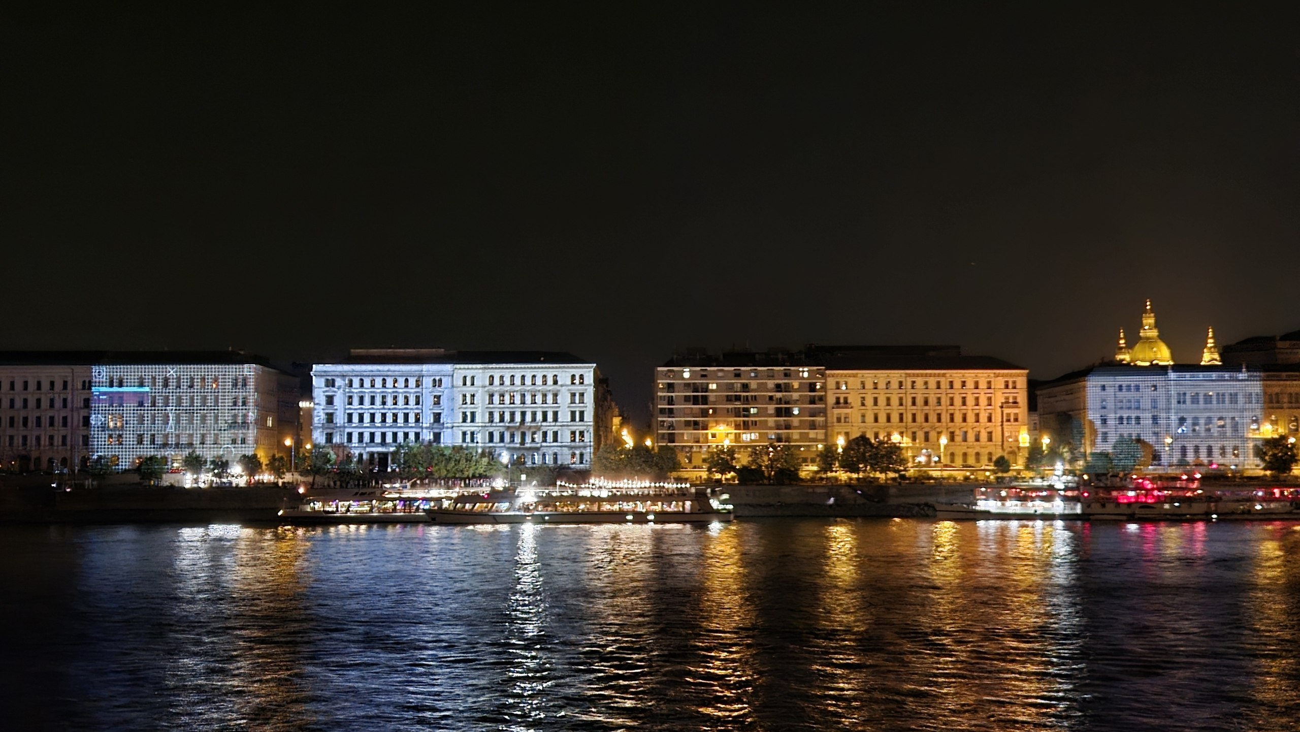 Illuminated buildings reflected in the Danube at night in Budapest