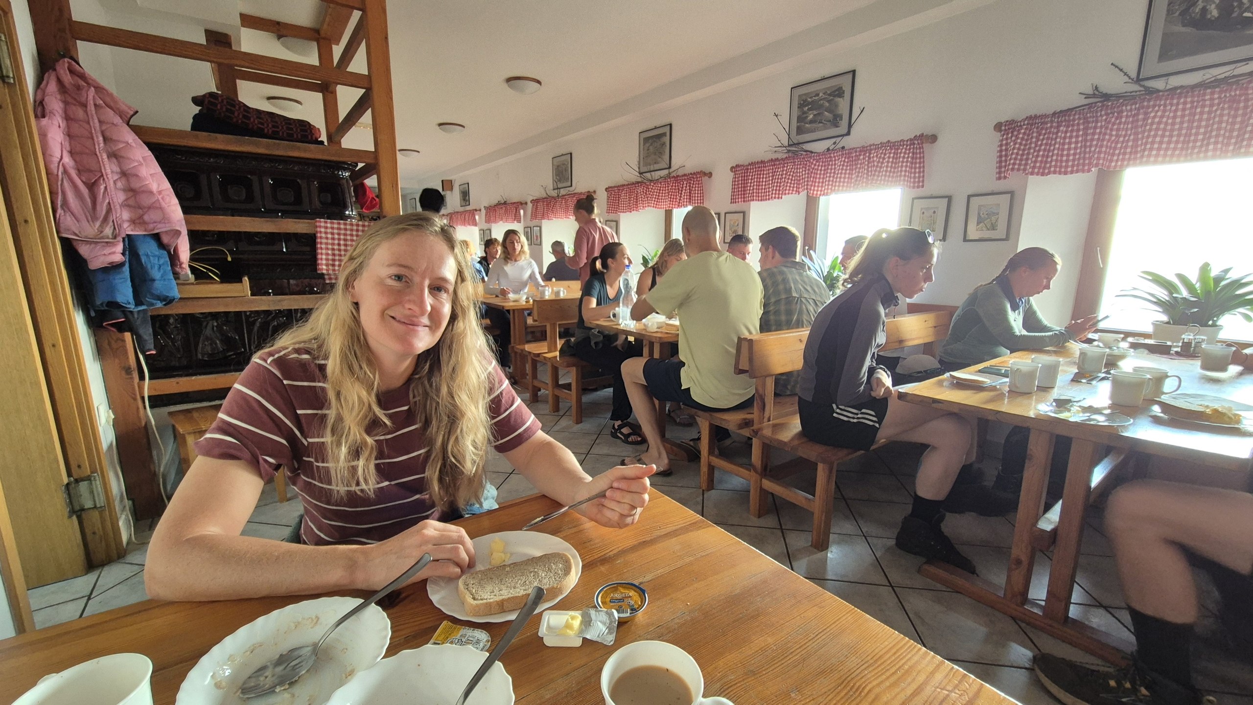 Caro eating breakfast in the busy dining room at Dom na Komni