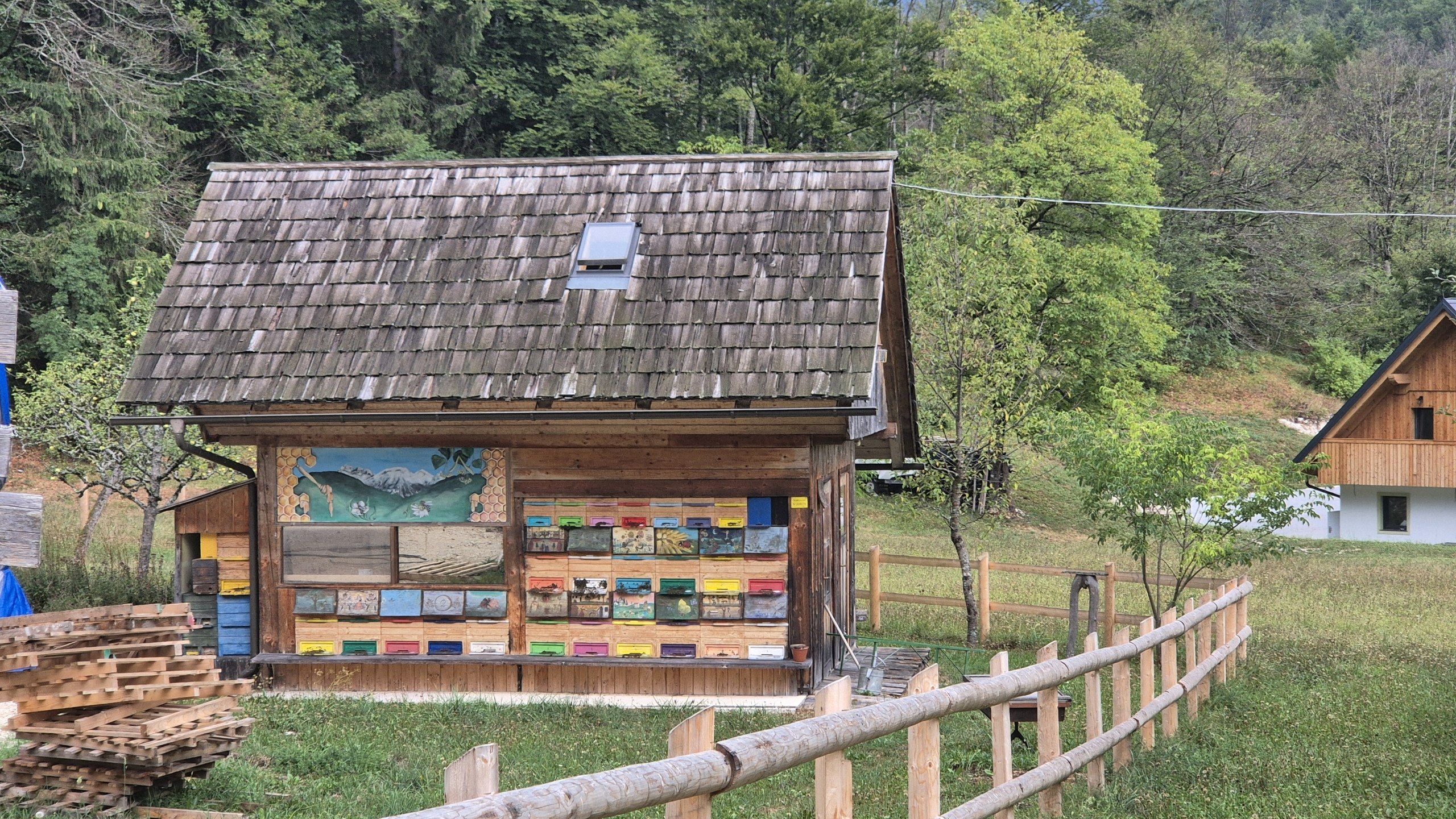 Rows of colourful painted beehive panels on a wooden apiary near Bohinj