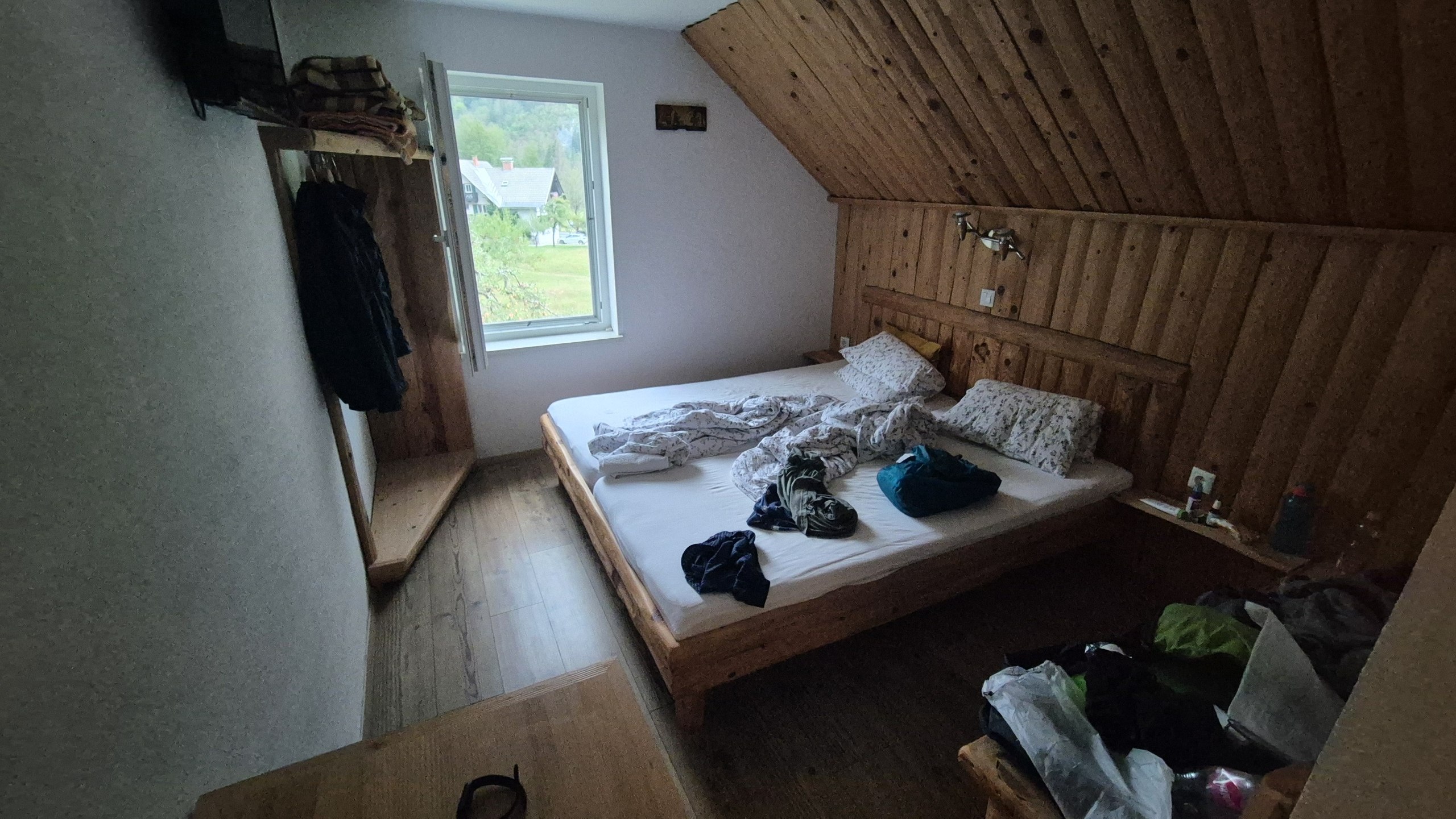 Wood-panelled bedroom beneath the sloping roof of the apartment