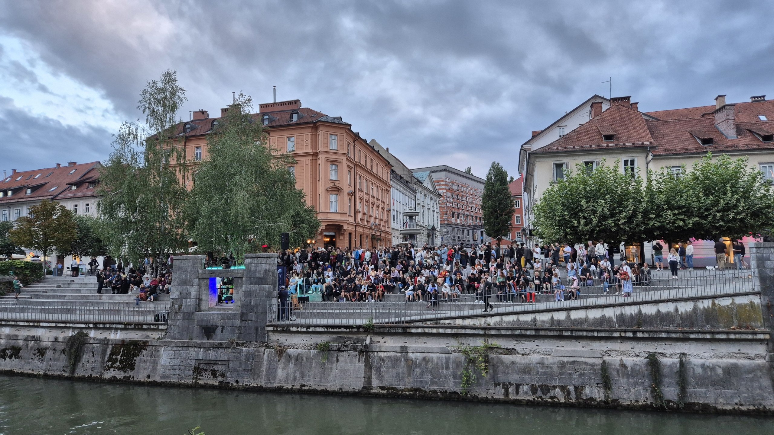 A crowd gathered for a free street concert beside the Ljubljanica River