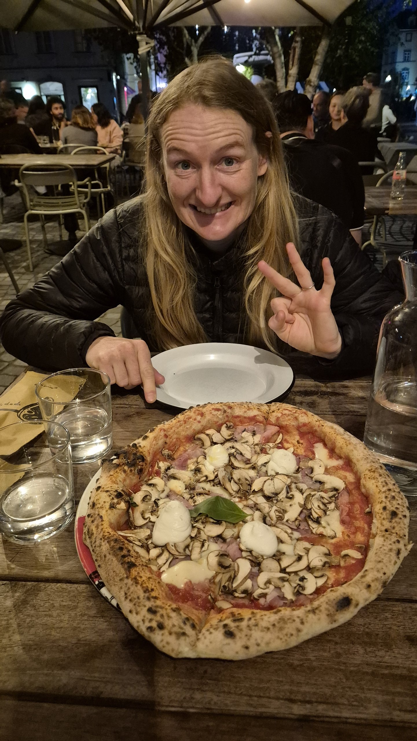 Caro with our third pizza in Slovenia beside a folk-music concert
