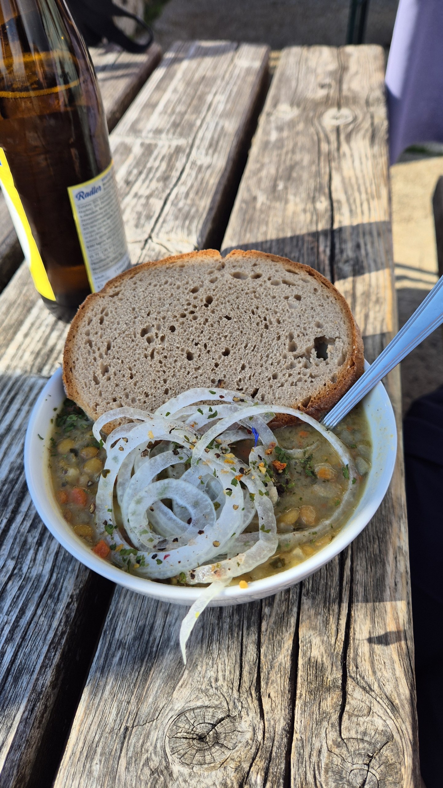 Bowl of lentil stew with onions and bread at the mountain hut