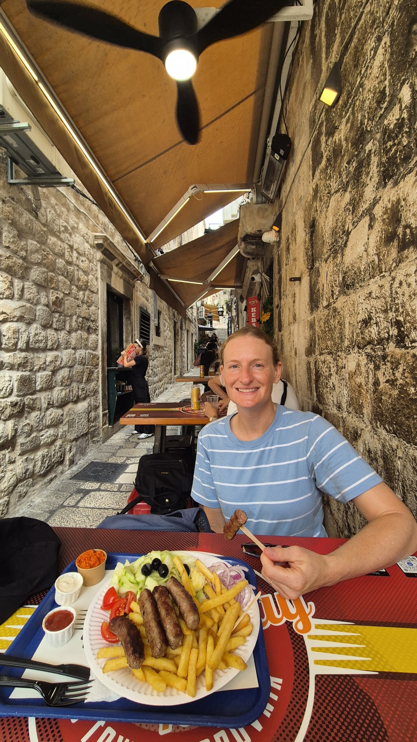 20260911_121404 Caro with a plate of cevapi and chips in Dubrovnik