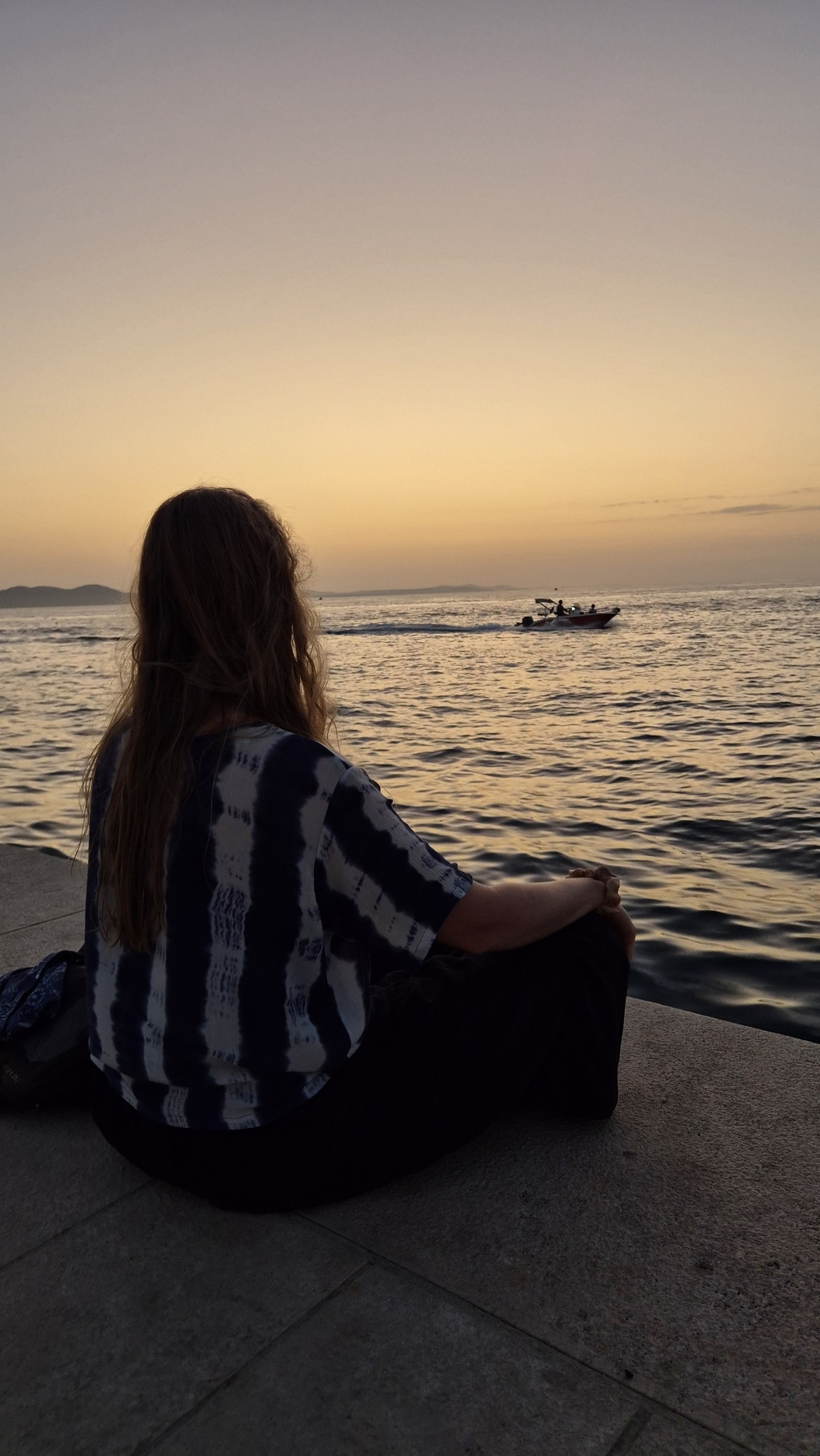 Caro sitting on Zadar's waterfront at sunset