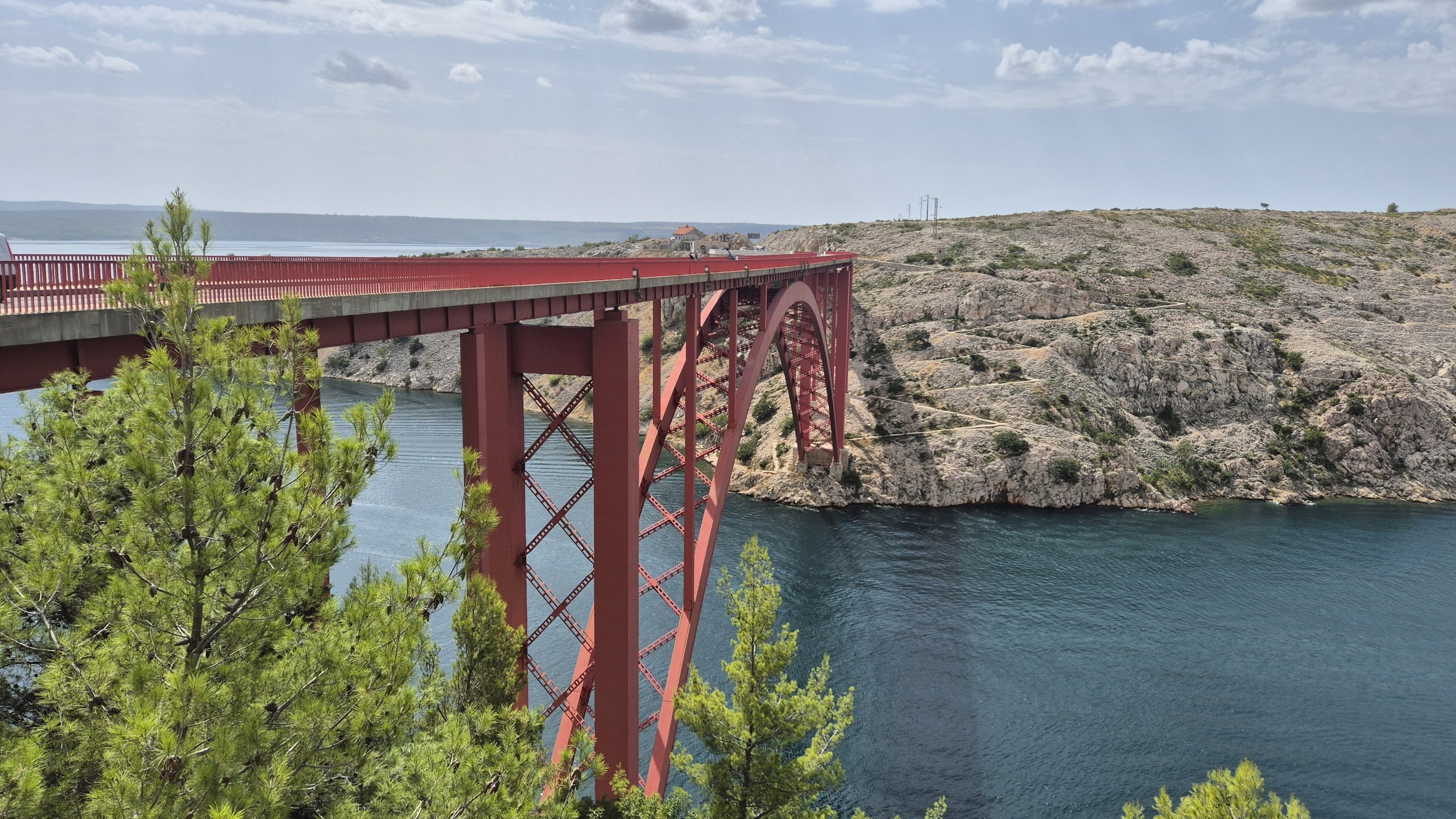 The red Maslenica Bridge spanning the blue water and rocky gorge