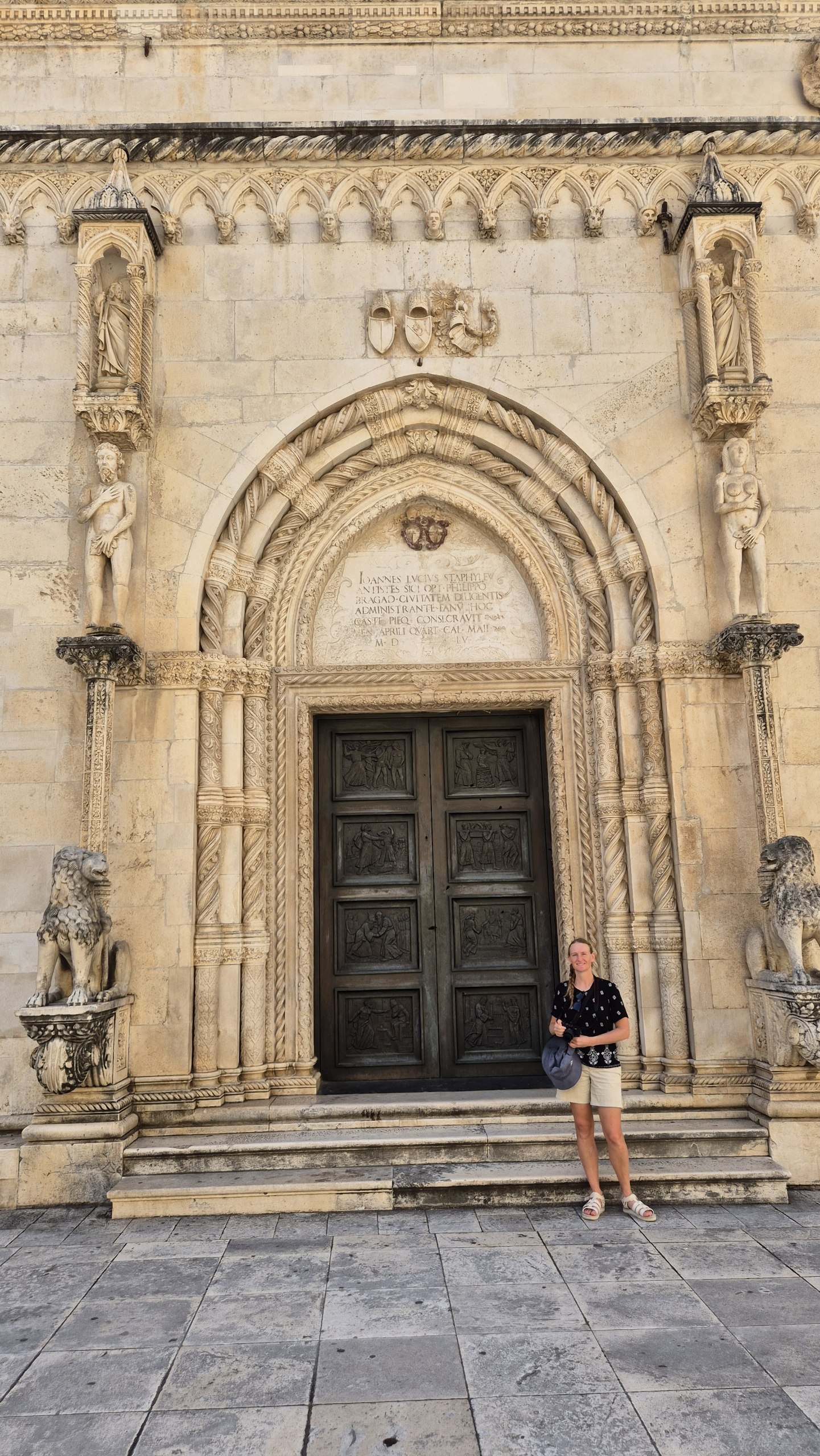 Caro standing beside an ornate carved doorway at the Cathedral of St James