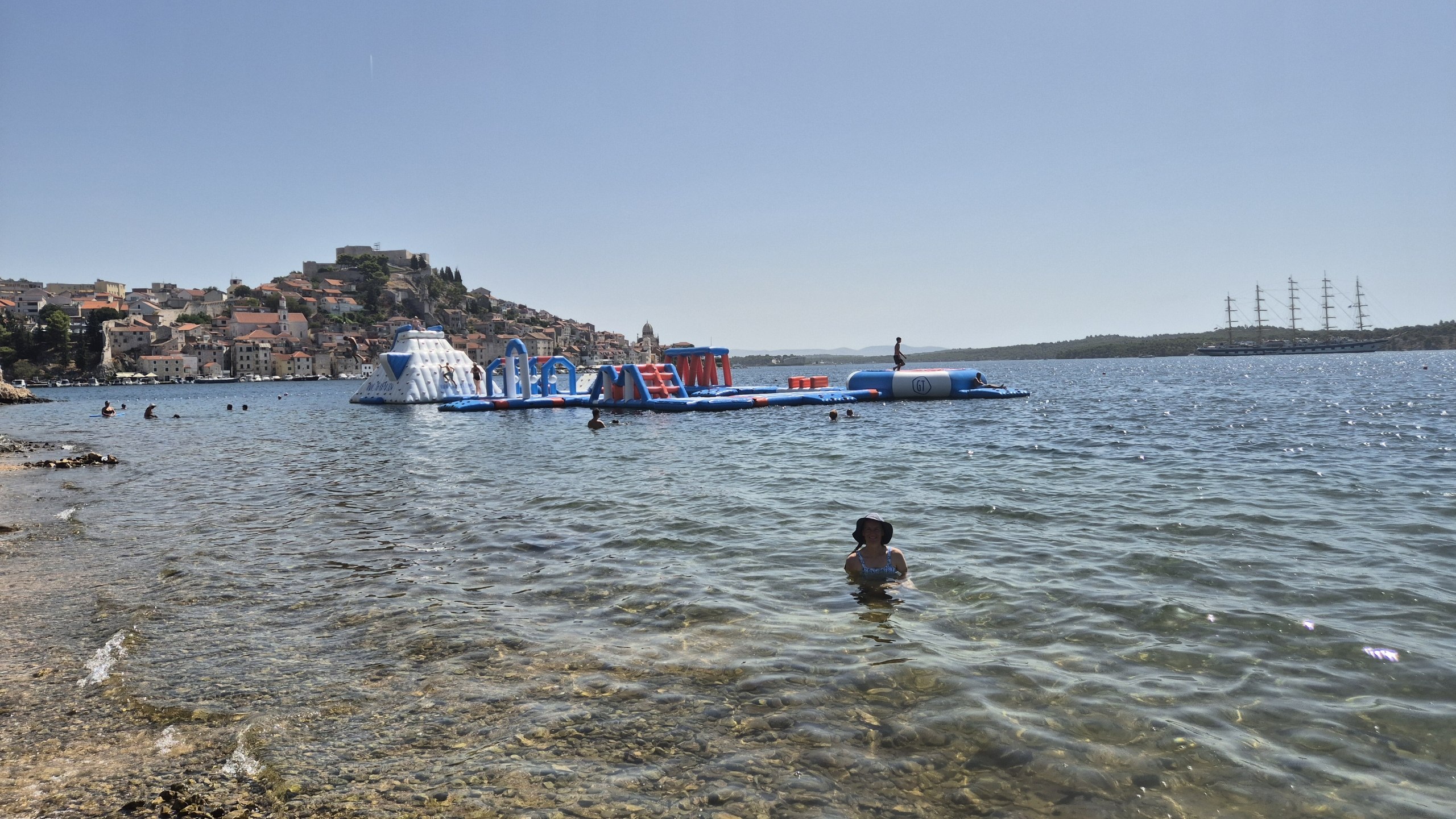 Caro swimming with Šibenik old town and the waterfront behind her