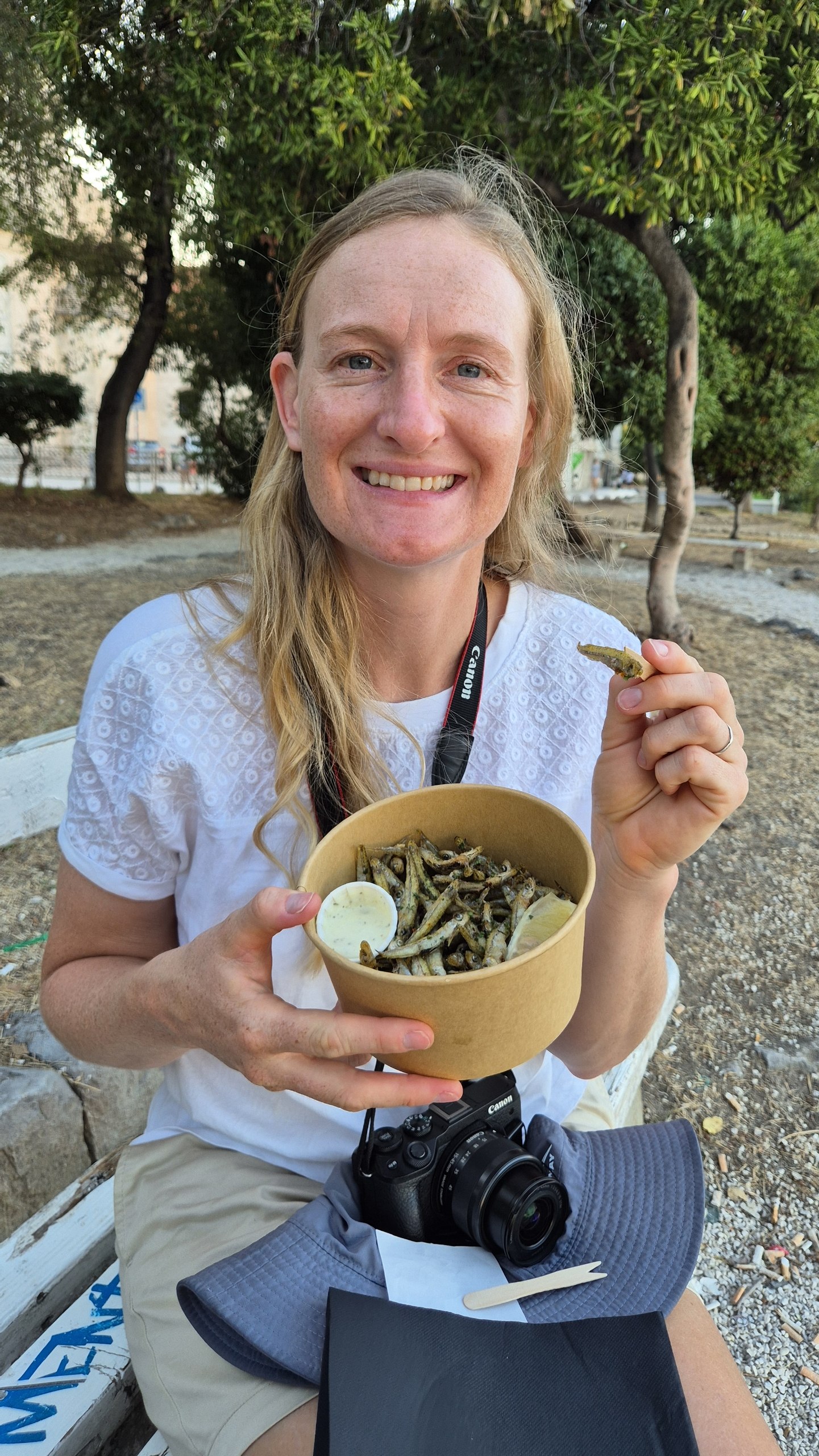 Caro holding a container of fried girice in Trogir