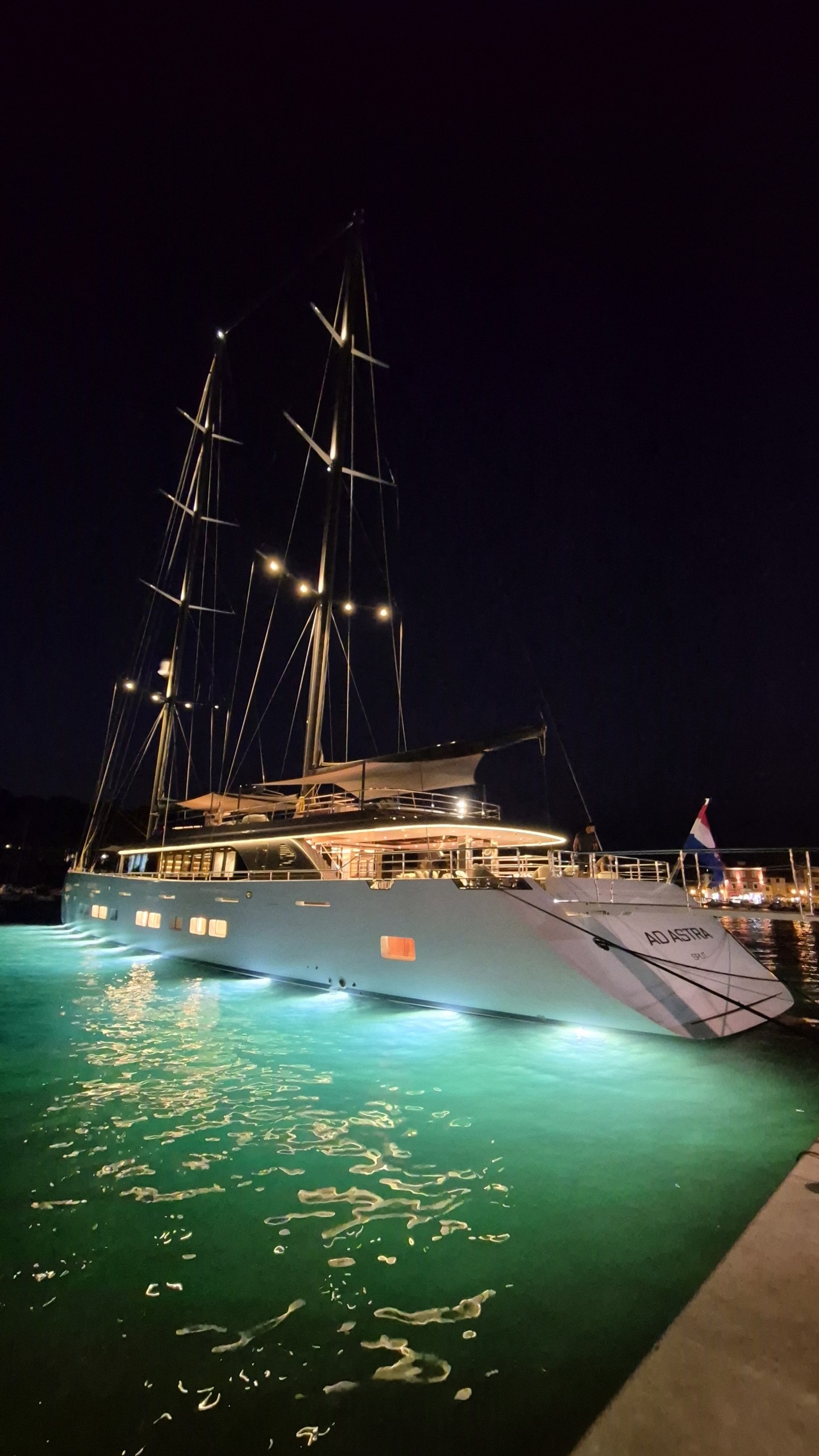 The large Ad Astra charter yacht illuminated in Stari Grad harbour at night