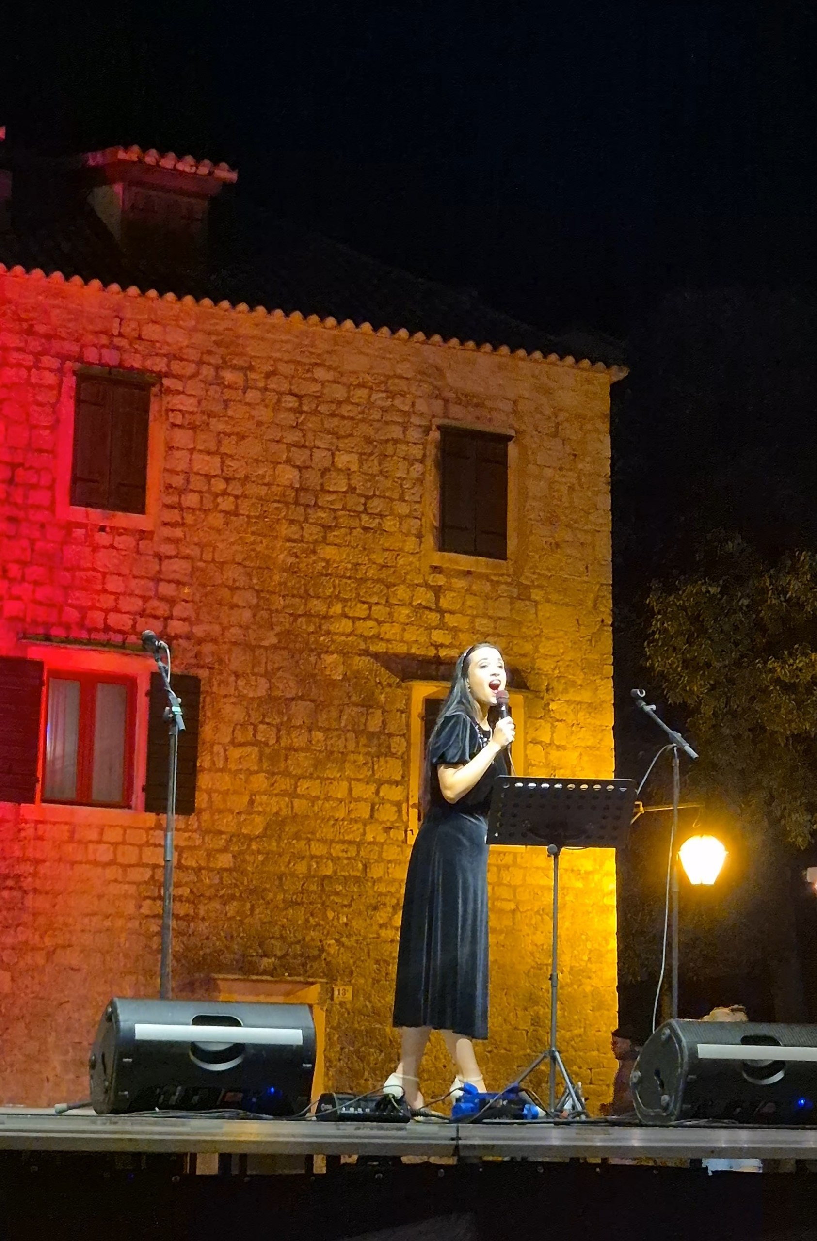 Opera singer performing on an outdoor stage in Stari Grad town square