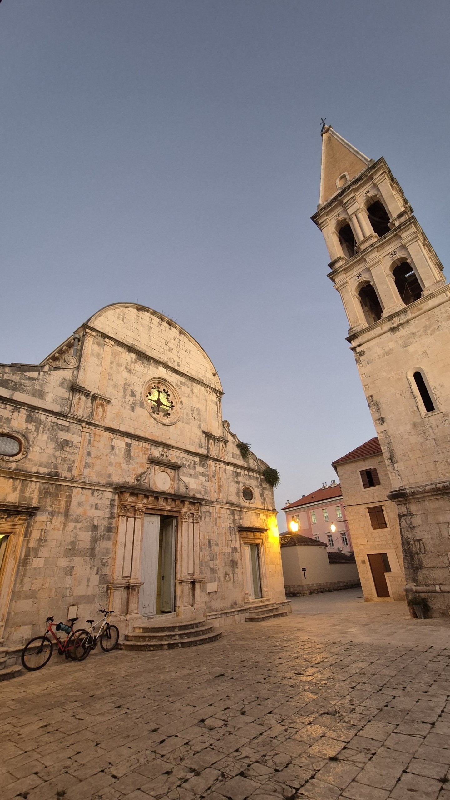 Historic stone church and bell tower in Stari Grad at dusk