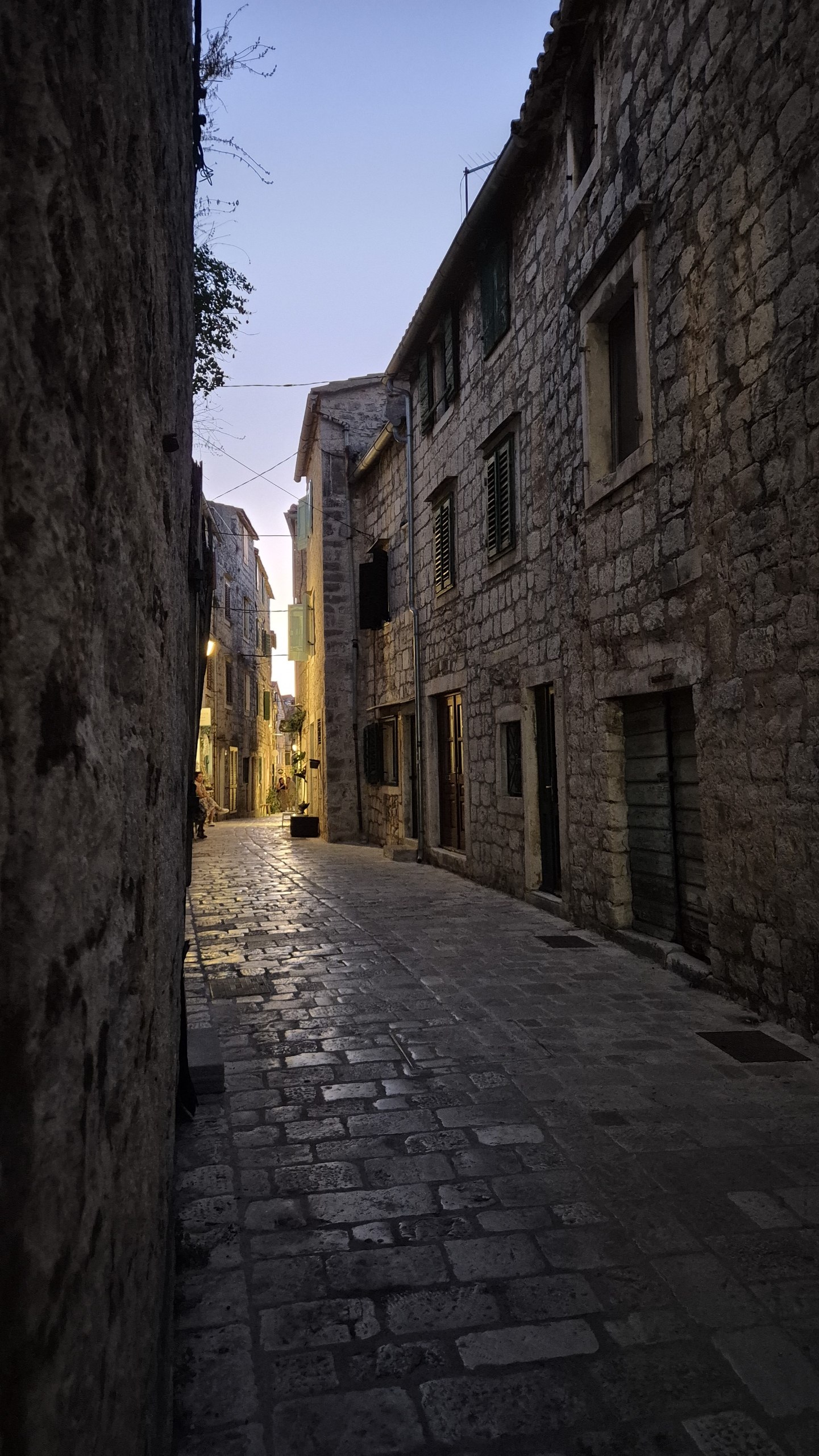 Narrow stone-paved lane between old houses in Stari Grad