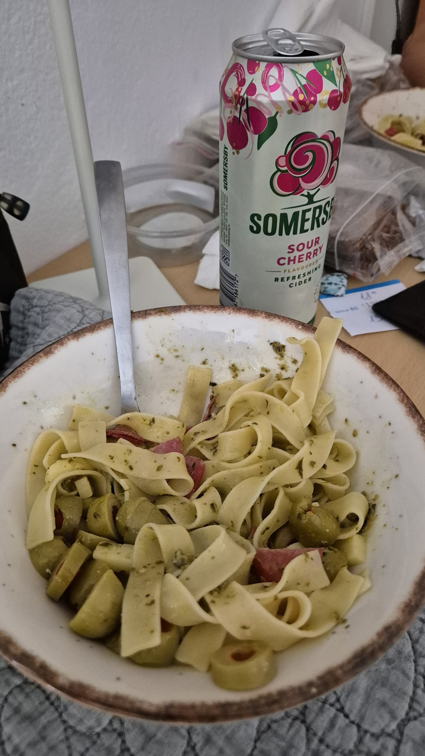 Pasta with pesto, olives, salami and cheese beside a sour cherry cider