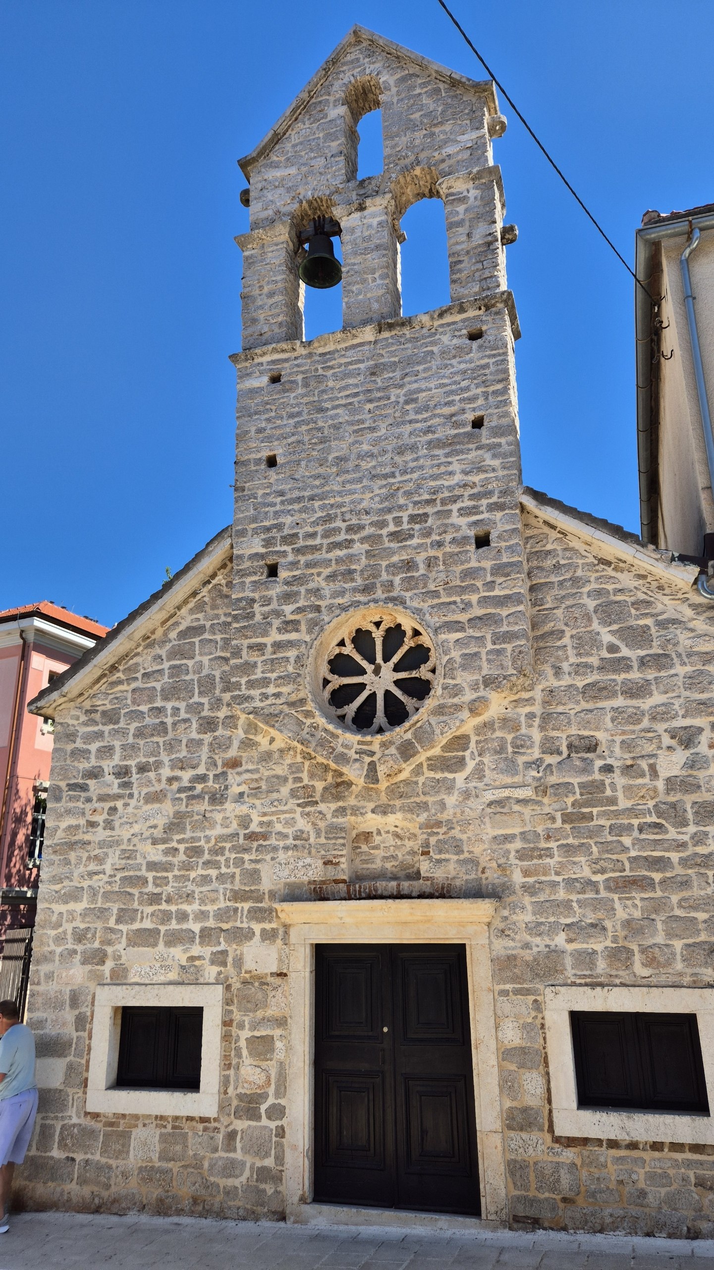 Small historic stone church in Stari Grad under a blue sky