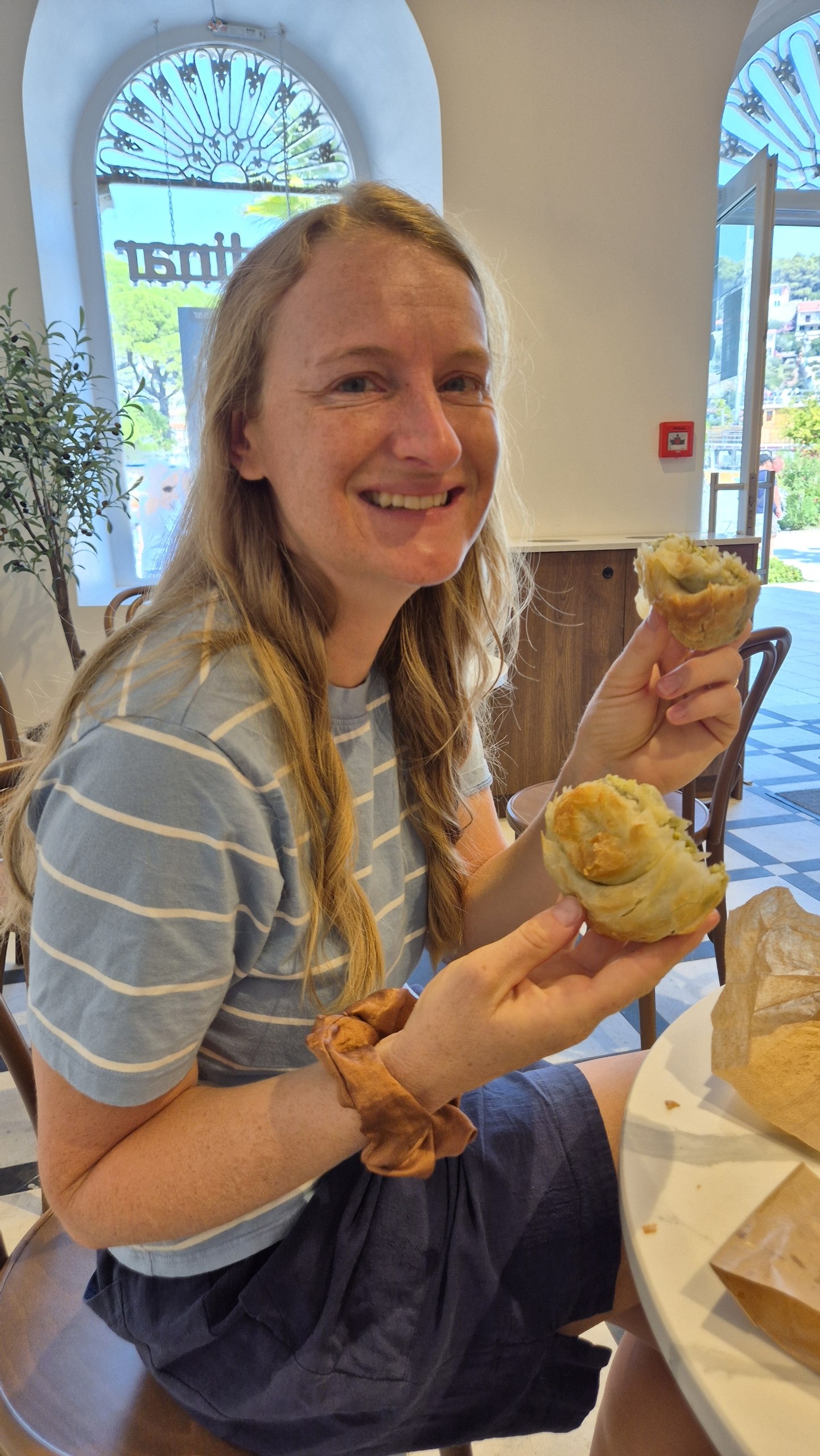 Caro holding spinach and cheese and potato burek in Jelsa