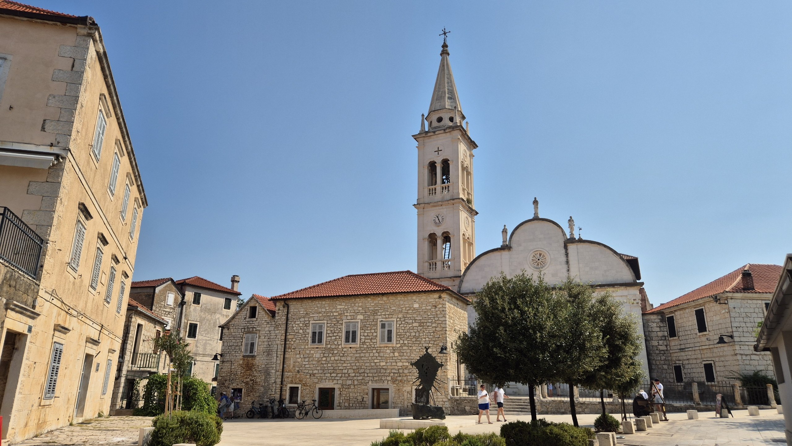 Stone church and bell tower in a quiet square in Jelsa