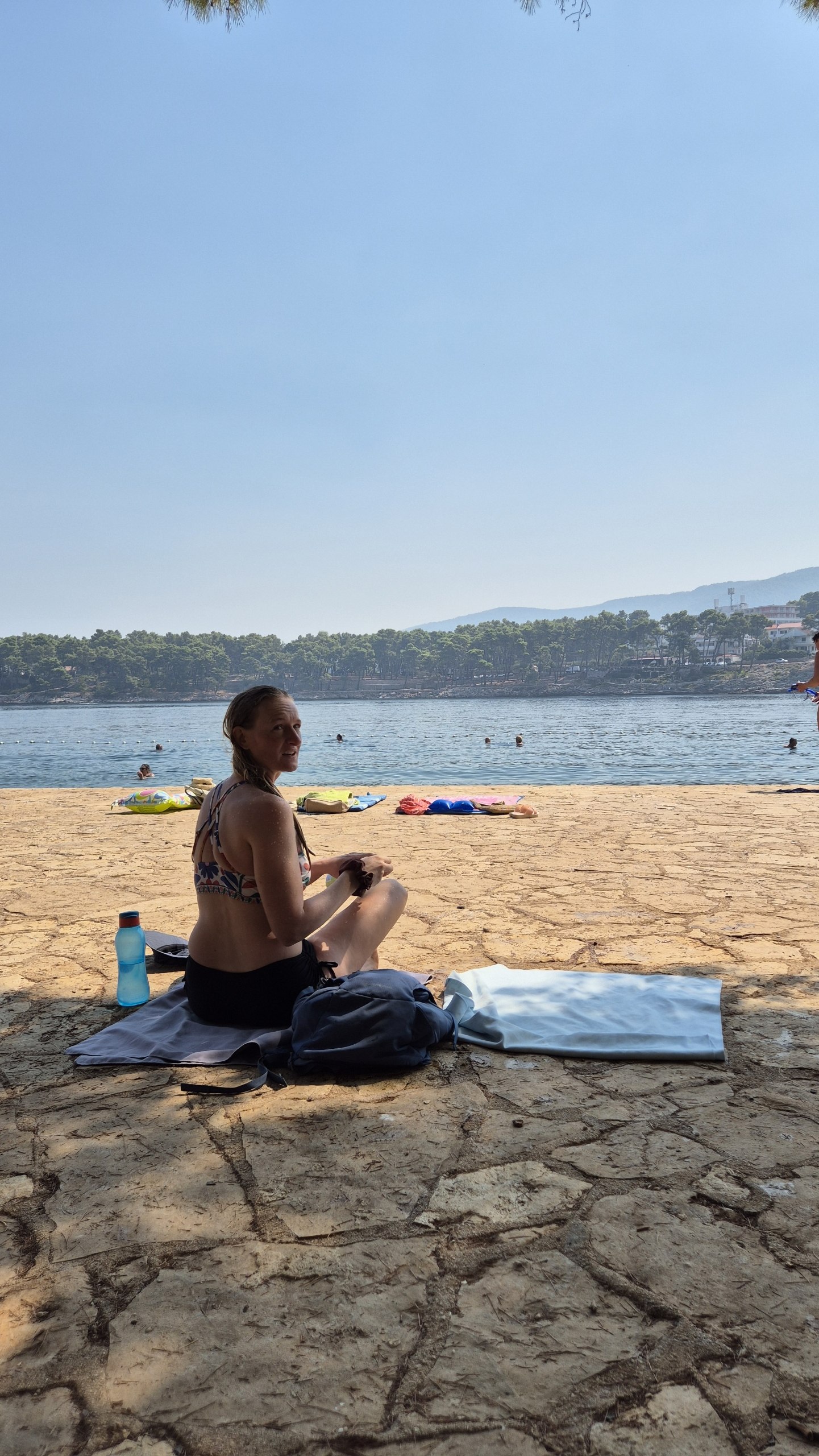 Caro sitting beside the first swimming spot near Jelsa, reached from a concrete platform by the harbour