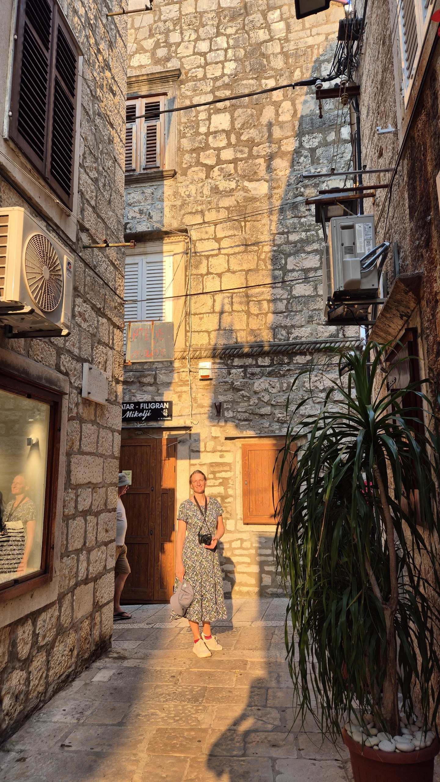 Caro standing in a shaft of morning sunlight in Korcula old town