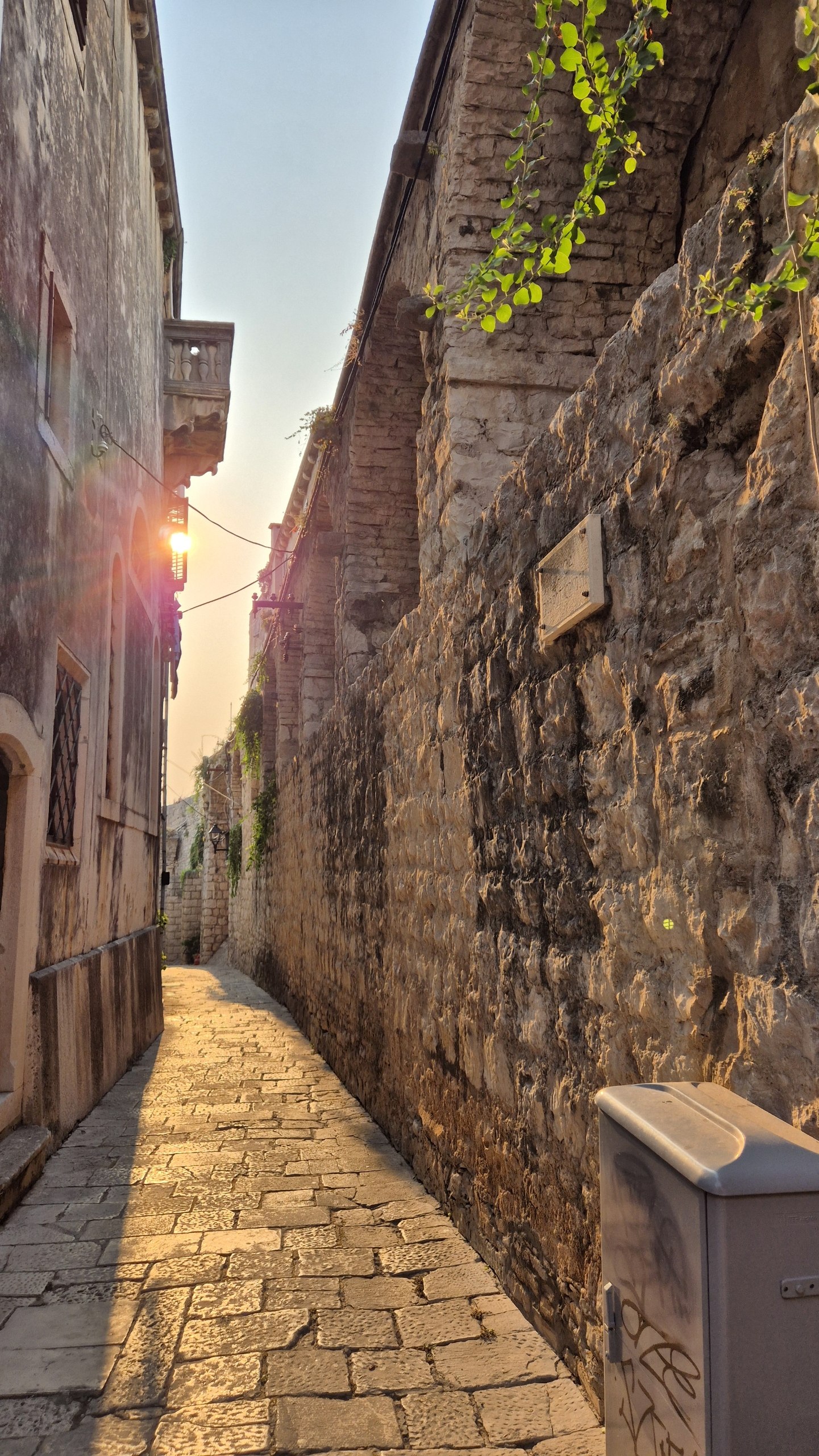 A narrow stone lane in Korcula old town lit by the early morning sun