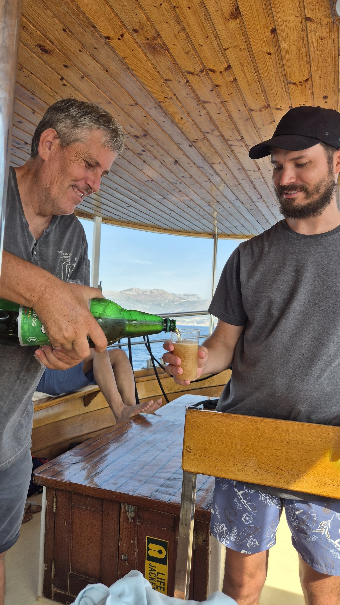 The captain pouring Hugo a drink aboard Ribica