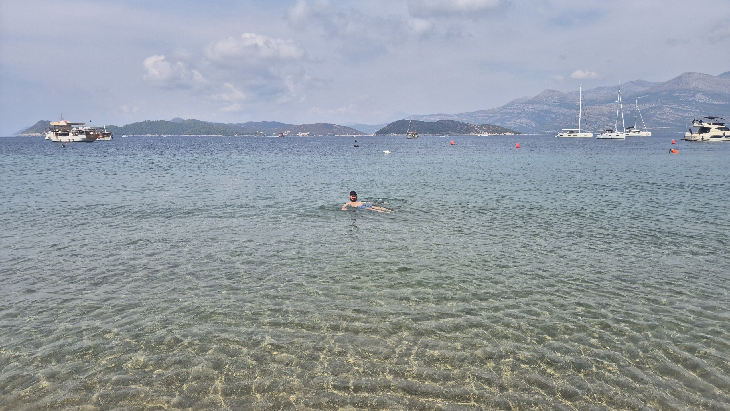 Hugo swimming in the clear shallow water at Lopud