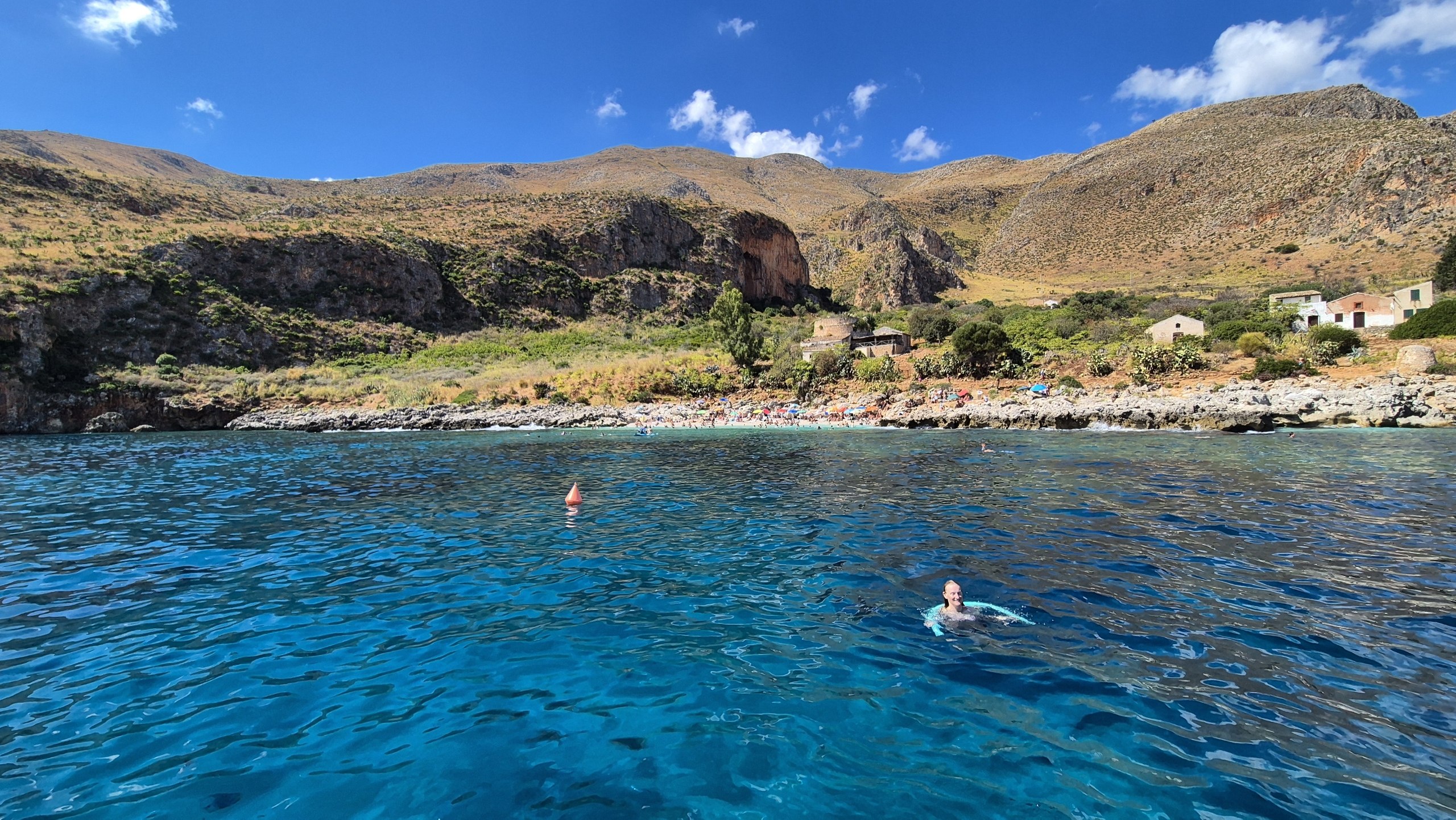 day49-swimming-in-cove A swimmer in the turquoise water of a quiet cove