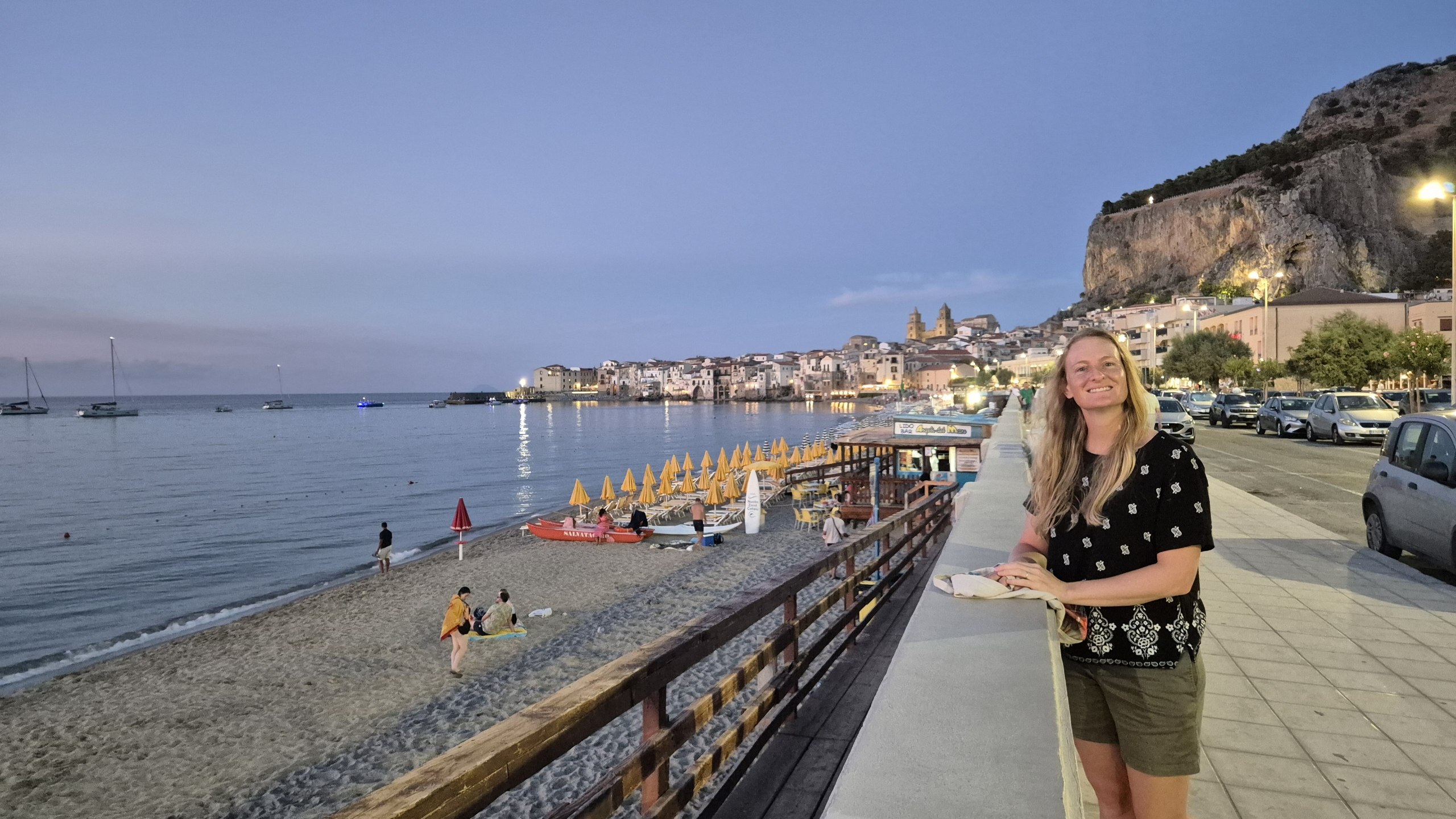 day52-cefalu-promenade-caro Caro on the Lungomare promenade with the old town and La Rocca behind