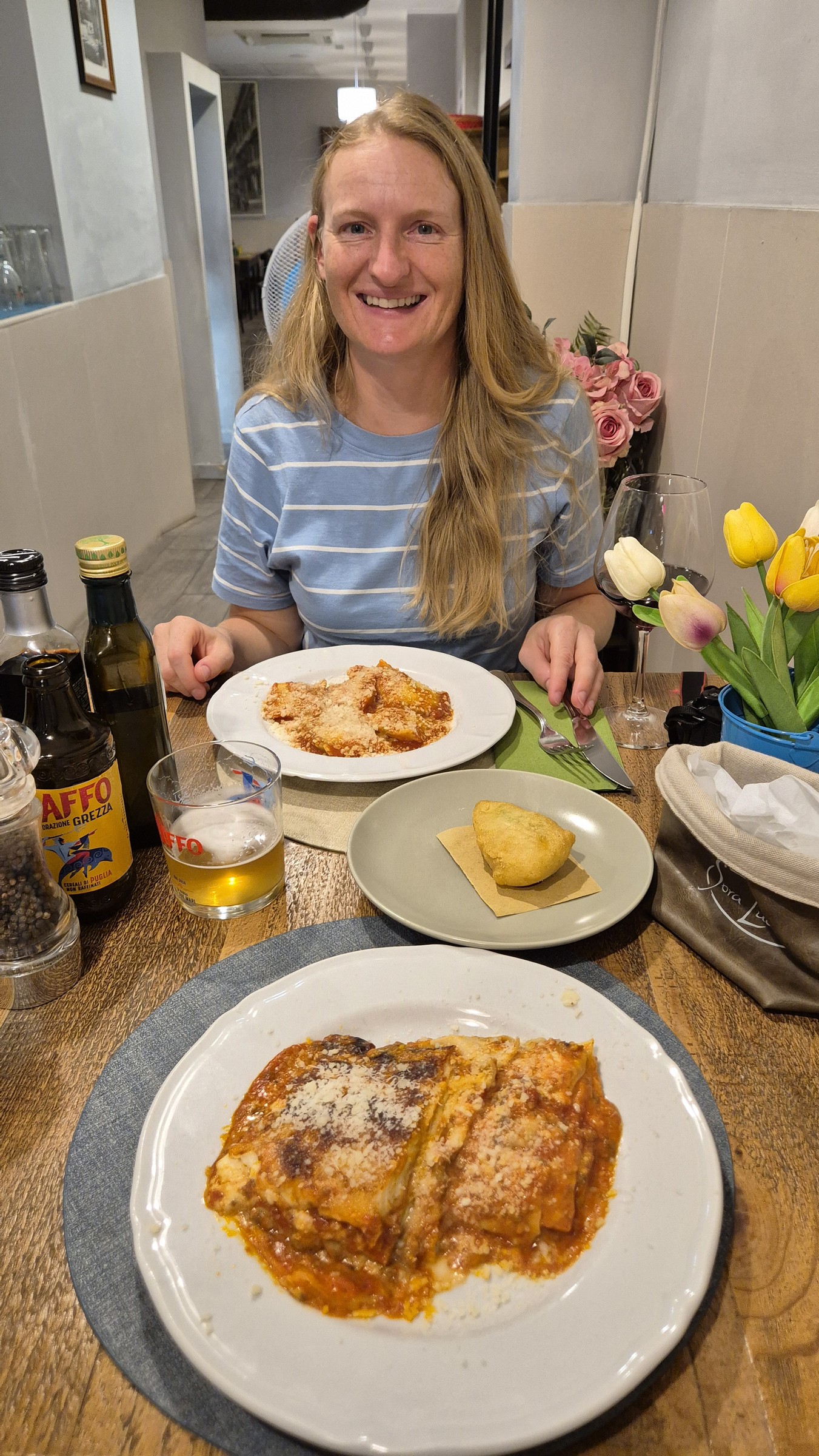 day65-caro-dinner Caro at dinner with lasagne and ravioli on the table