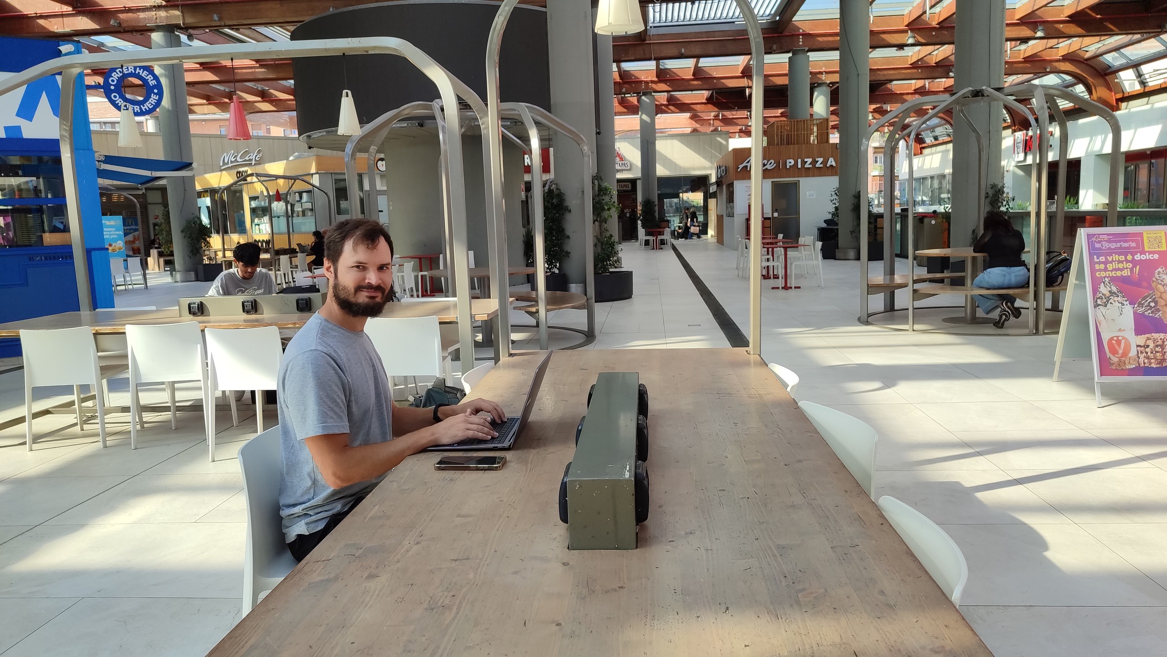 day67-hugo-working-rome-mall Hugo working at the communal table in the mall near the Rome apartment