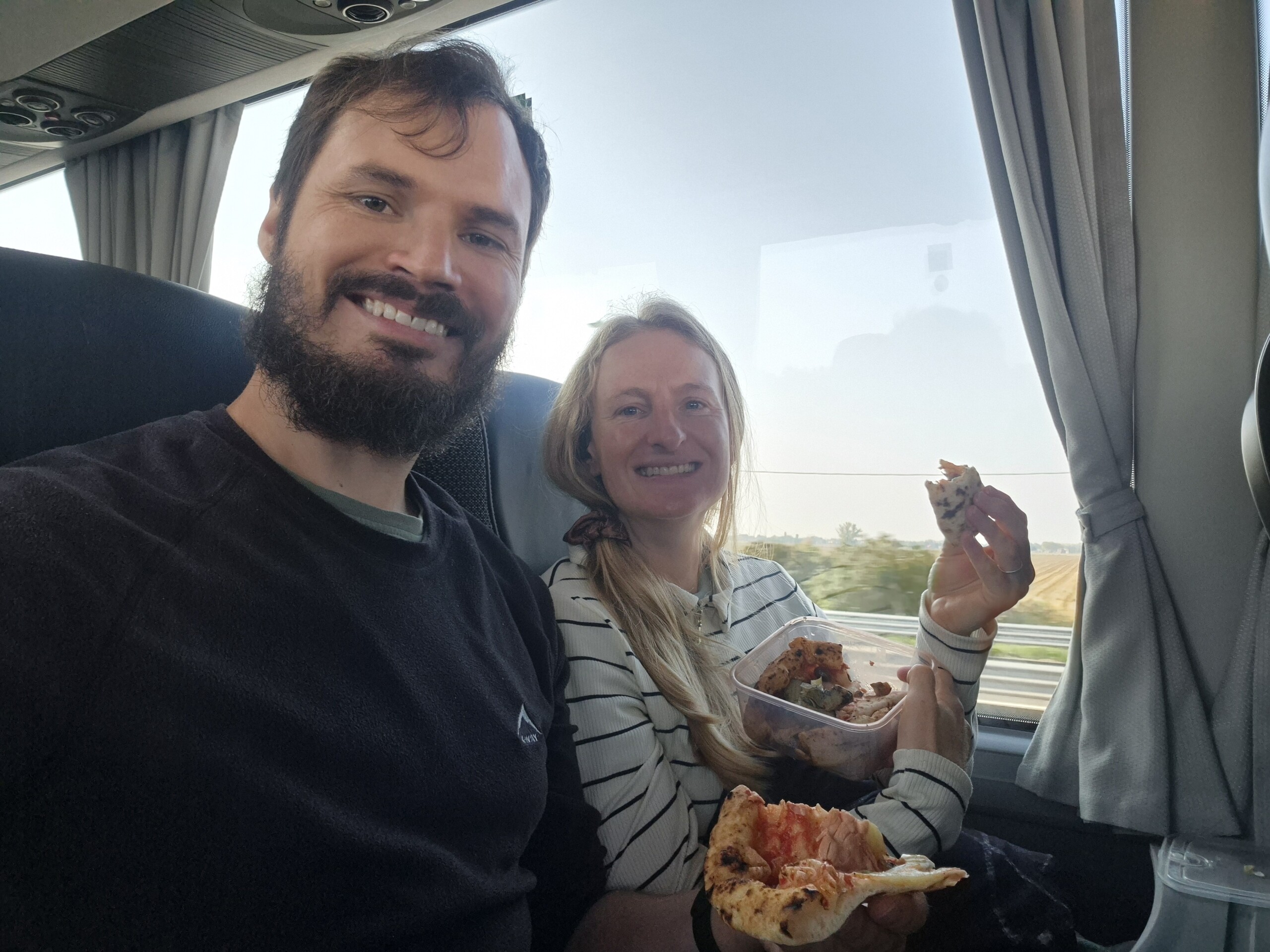 Hugo and Caro eating leftover pizza on the replacement bus from Bologna